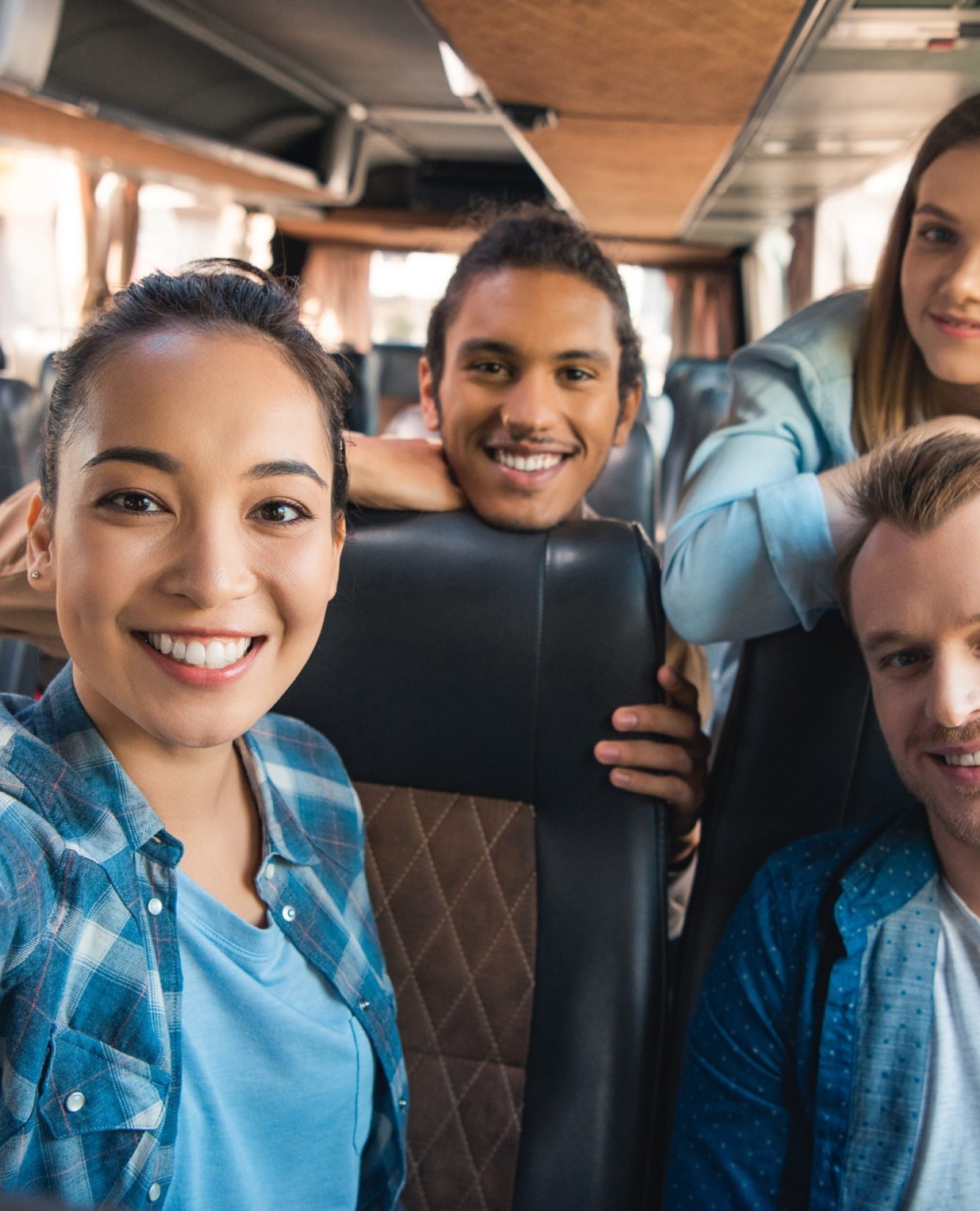 selective-focus-of-smiling-asian-woman-taking-selfie-with-multicultural-friends-in-travel-bus.jpg